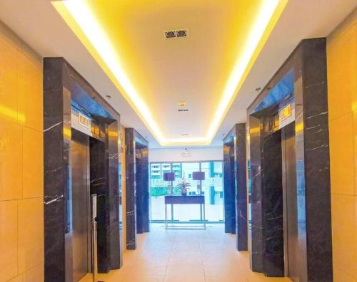 a hallway with a row of elevators in a building at Cozy New 1BR Fame Residences Condo with Balcony in Manila