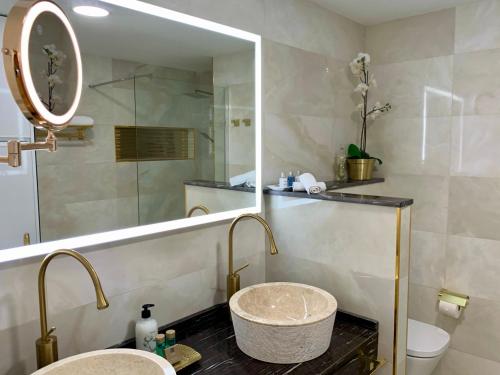 uma casa de banho com um lavatório, um espelho e um WC. em Doñana 1027 em Patalavaca