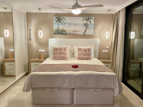 um quarto com uma cama branca com uma rosa vermelha em Doñana 1027 em Patalavaca