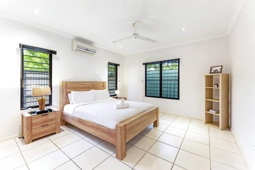 een slaapkamer met een bed en 2 ramen bij Ah Mat Bungalow - Tropical Darwin Stay with Pool in Parap