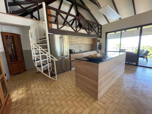 a kitchen with a staircase in the middle of a room at Villa Te Miti in Punaauia