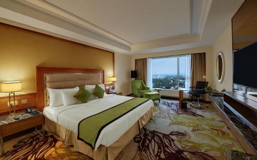 a hotel room with a bed and a large window at Sayaji Kolhapur in Kolhapur