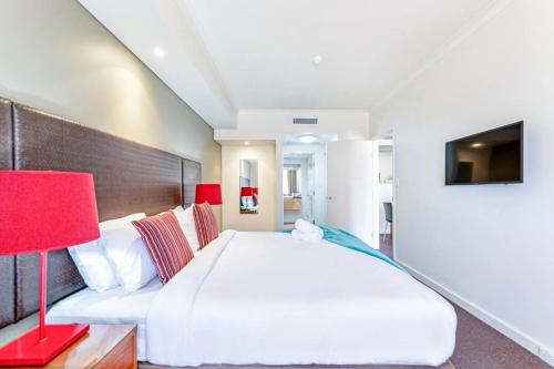 A bed or beds in a room at Waterfront on the Esplanade with Tropical Pool