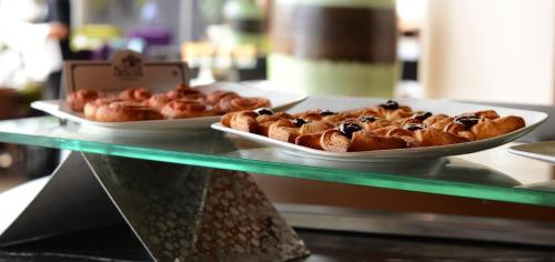 two plates of pastries sitting on a glass shelf at Sayaji Kolhapur in Kolhapur