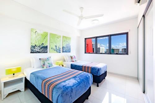 ダーウィンにある'The Smith' A Vibrant Poolside Balcony Havenのベッド2台と窓のある寝室