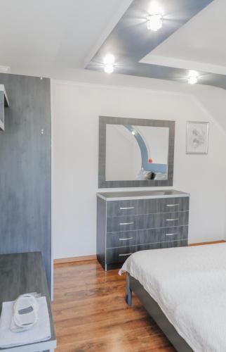 a bedroom with a bed and a dresser with a mirror at Фенікс in Yaremche