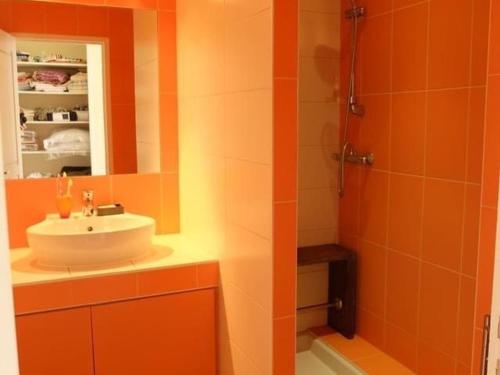 La salle de bains orange est pourvue d'un lavabo et d'une douche. dans l'établissement Maison mitoyenne avec jardin clos et terrasse à 200m de la plage - Vieux Port de Pornic - FR-1-306-1213, à Pornic