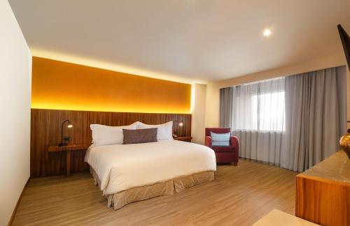 a hotel room with a bed and a chair at Camino Real Aeropuerto in Mexico City