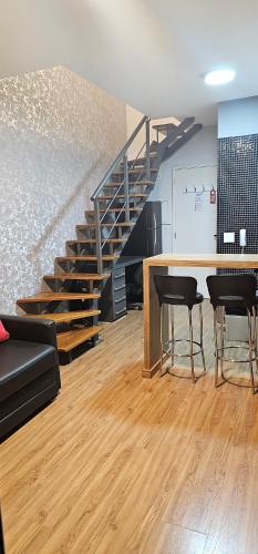 a living room with a staircase and a table and chairs at Duplex NYC Berrini - 1506 in Sao Paulo