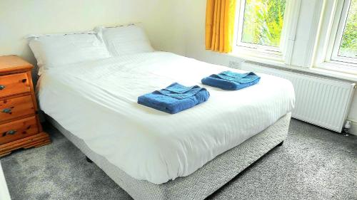 2 toallas en una cama blanca con ventana en C-New Flat,4 Adults,20 mins to Beach,Netflix,Wifi, en Bournemouth