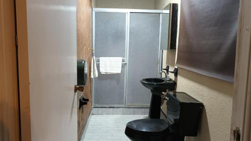 a bathroom with a black toilet and a sink at Fitness Suite in Tijuana
