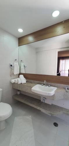 a bathroom with a sink and a mirror and a toilet at Duplex NYC Berrini - 1506 in Sao Paulo