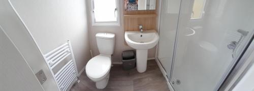 a small bathroom with a toilet and a sink at Lake view in Newquay