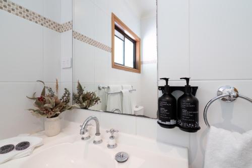 a bathroom with two bottles of wine on a sink at Hermitage Lodge in Pokolbin
