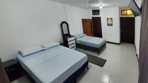 um quarto de hospital com duas camas e um espelho em Casa Isabella 45 em Matagalpa