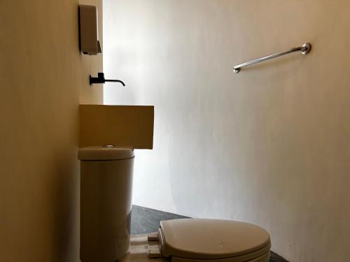 a bathroom with a toilet in a room at Highland Bali in Baturaja
