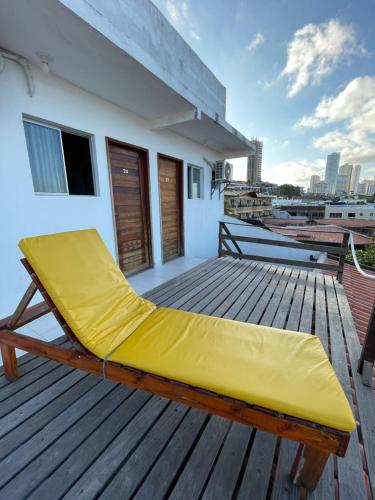 a yellow bed on the deck of a house at Encanto da Praia hotel pousada in Natal