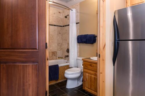 a small bathroom with a toilet and a refrigerator at Penthouse Studio w Mtn Sunrise Views & Near Silver Mtn in Kellogg