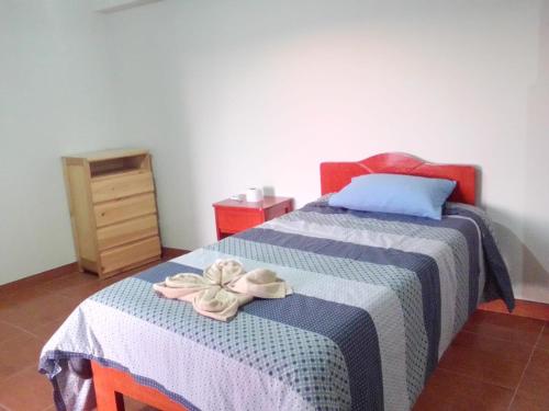 um quarto com uma cama com um cobertor azul e branco em Casa Tejedora em Chincheros
