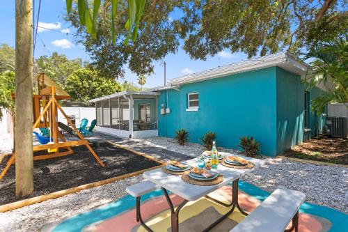 a blue house with a picnic table and a swing at 5 min Beaches~Mini Golf~Pool Table~Pets~KING BED + in Largo