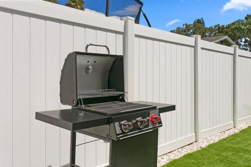 a grill sitting next to a white fence at 5 min Beaches~Mini Golf~Pool Table~Pets~KING BED + in Largo