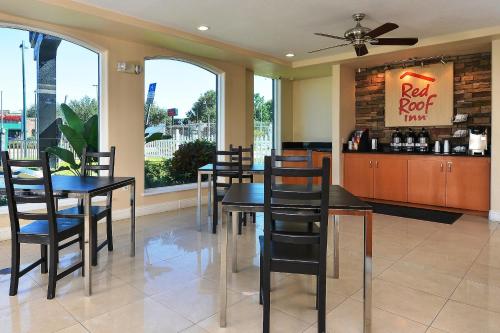 a restaurant with tables and chairs and a bar at Red Roof Inn Orlando South - Florida Mall in Orlando