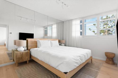 a white bedroom with a large bed and a window at Harbour Bliss - Exquisite Design, Breathtaking Views in Sydney