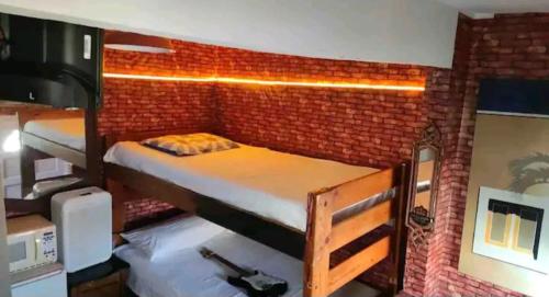 a room with two bunk beds in a brick wall at Tree Cabin in Tijuana