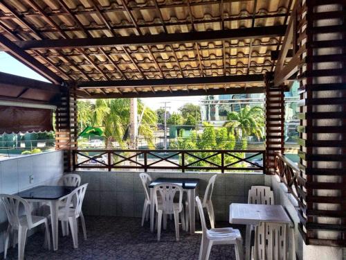 um restaurante com mesas e cadeiras e uma varanda em Pousada São José em Fortaleza