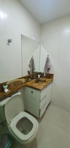 a bathroom with a toilet and a sink at Pousada da Drica in Saquarema