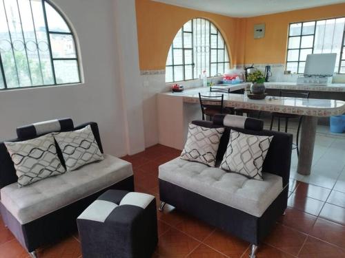 a living room with two couches and a kitchen at 2 Cuarto independiente en Ambato in Ambato