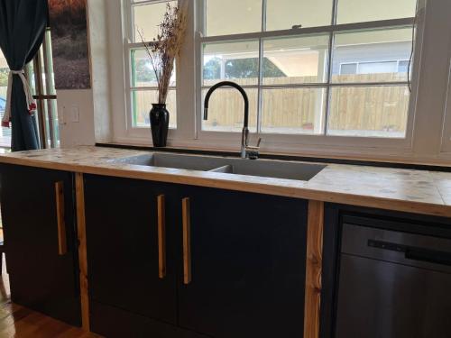 a kitchen counter with a sink and a window at The Green House Dening Street Robe in Robe