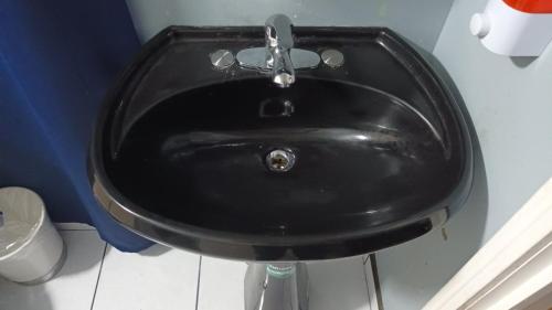 a black sink with a faucet in a bathroom at Elegant Suite in Tijuana
