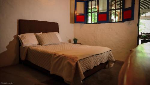 una camera con letto e finestra istoriata di La Cabaña Cleves a Neiva