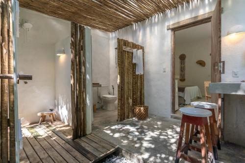 a bathroom with a toilet and a sink and a mirror at Suítes Casa Kamayurá in Trancoso