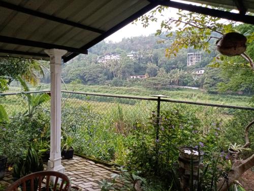 a view from the porch of a house with a view of a field at Mahaweli Shades in Kandy