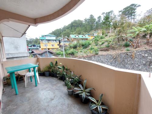 uma varanda com uma mesa azul e vasos de plantas em GDN Inn 