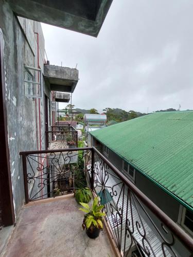 uma varanda de um edifício com um telhado verde em GDN Inn 