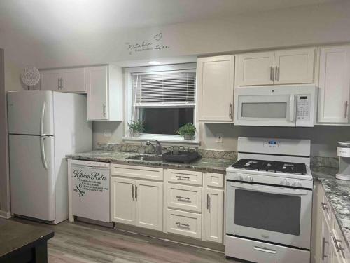 a kitchen with white appliances and white cabinets at Cozy Home Away from Home in Clayton