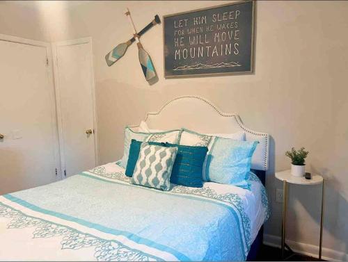 a bedroom with a bed with blue and white pillows at Cozy Home Away from Home in Clayton