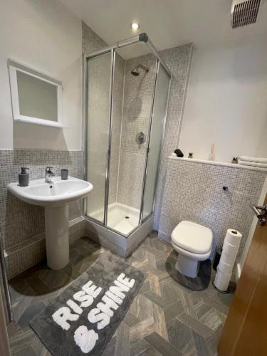 a bathroom with a shower and a sink and a toilet at Coventry City Centre 2 Bed 2 Bath Apartment With FREE Secured Parking, Balcony, PS4 - Reverie Stays in Coventry