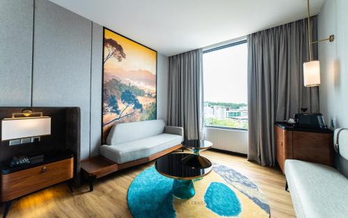 a living room with a couch and a table in a room at Mercure Miri City Centre in Miri