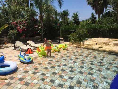 a group of children playing in a pool with inflatable toys at De Michanna in Anarita