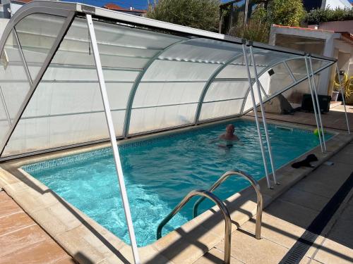 a man in a swimming pool under a cover at villa Lagoa in Óbidos