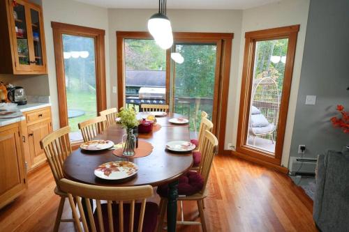 a kitchen with a wooden table with chairs and a dining room at Stairway To Heaven-VT Lakefront! in Eden