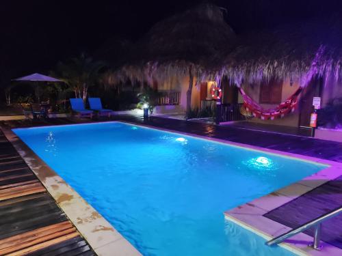 a swimming pool lit up at night at Hotel Isabella Tayrona in Los Naranjos