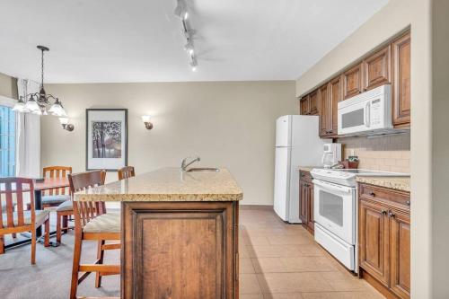 a kitchen with white appliances and a table and chairs at Spacious Hideaway in Nature in Edgar