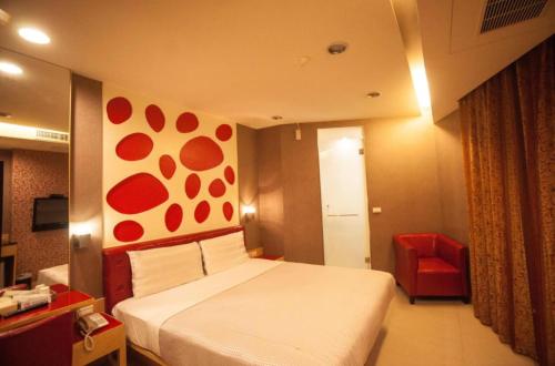 a hotel room with a bed and a red chair at Love Hotel in Pingtung City