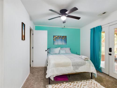 a bedroom with a bed and a ceiling fan at Pine Forest Zen Cottage - 10 min to Fort Bragg in Fayetteville