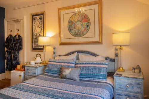 1 dormitorio con 1 cama con almohadas azules y blancas en Assemblage Boutique Art B & B en Hobart
